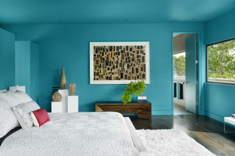 Cômodo grande e bem iluminado pelo janelão, móveis em cores neutras.