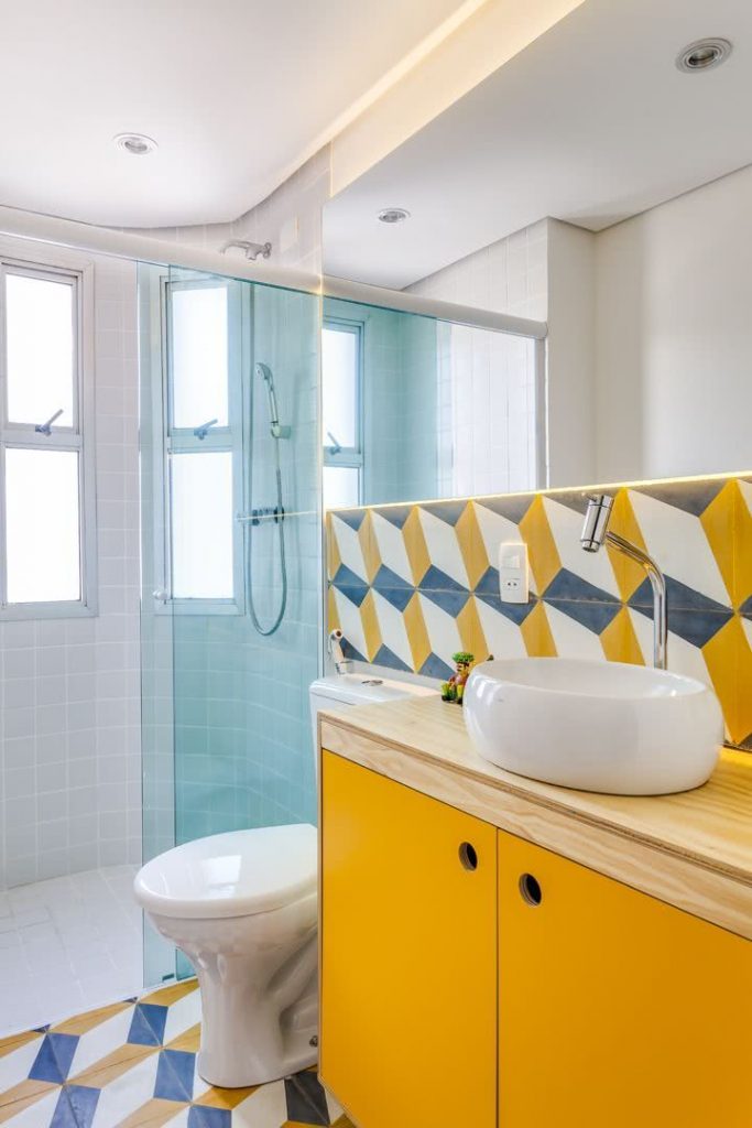 Um toque de cor no banheiro pequeno com os azulejos geométricos
