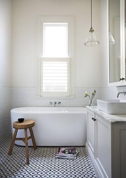 Banheiro simples com piso em azulejo preto e branco