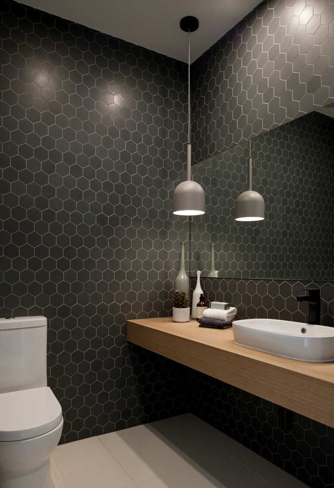 Pastilhas hexagonais pretas nas paredes com spots de luz para aumentar a iluminação