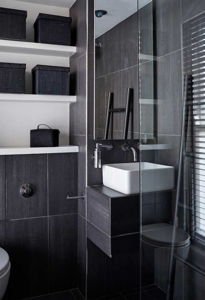 Banheiro pequeno simples com revestimento escuro e contraste com a louça