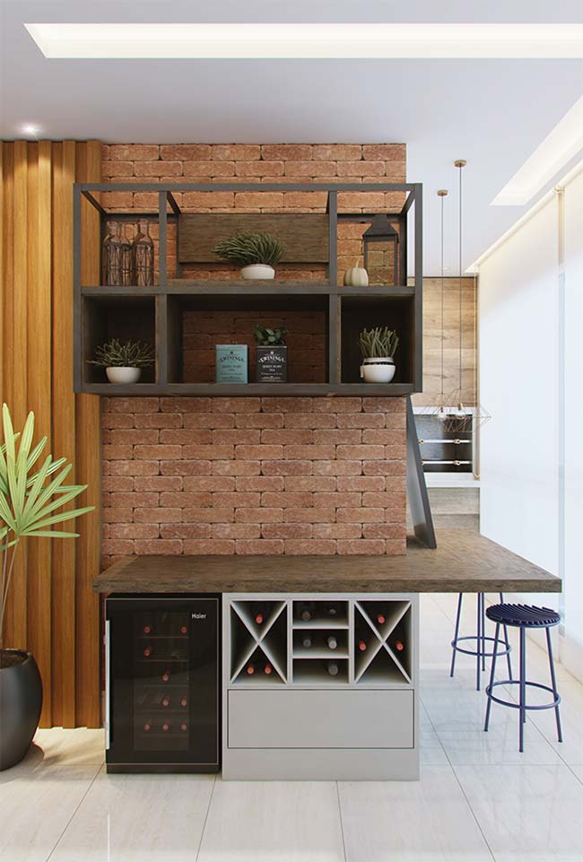 Parede de tijolinhos, madeira e uma mini adega dão o tom dessa varanda gourmet de apartamento.
