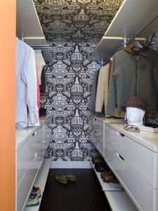 o closet ficou com muita personalidade com o papel de parede revestido até o teto.
