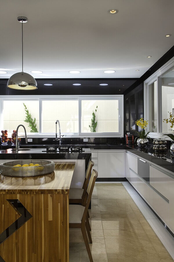 Na cozinha compacta preto e branca invista em uma boa iluminação natural