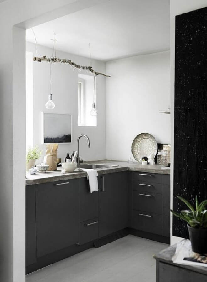 Decoração para cozinha compacta preto e branca com luminária minimalista presa em galho seco
