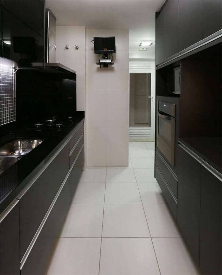 Na cozinha compacta preto e branca invista em basta iluminação e em móveis planejados