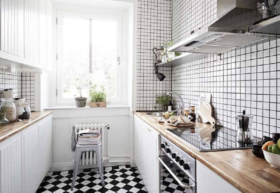Piso para cozinha preto e branco com decoração simples e bancada de madeira para armários planejados