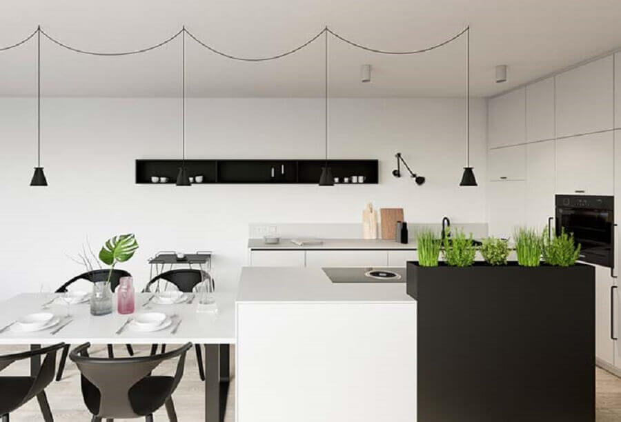 Decoração moderna para cozinha planejada preta e branca com uma pequena horta acoplada à ilha 